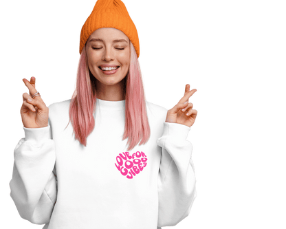 Frau mit rosa Haaren und orangener Mütze trägt den Bio-Sweatshirt "LOVE FOR GOOD VIBES" in gemütlichem Look.